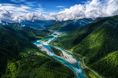 Aerial View of Crystal Clear River Flowing Through Lush Green Mountain Valley | AI Mountain Valley Image